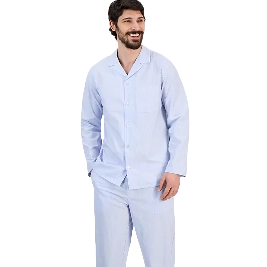 A man is wearing a light blue, long-sleeved, button-up pajama set with a collar and chest pocket, featuring a subtle striped pattern.