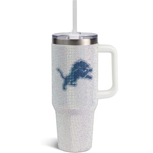 A rhinestone-studded tumbler with a handle and straw, featuring a blue silhouette of a jumping lion, indicative of the Detroit Lions NFL team.