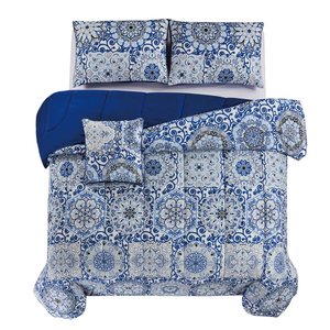 Blue and white bedding set with intricate floral patterns, featuring a comforter, two pillow shams, and a decorative pillow.