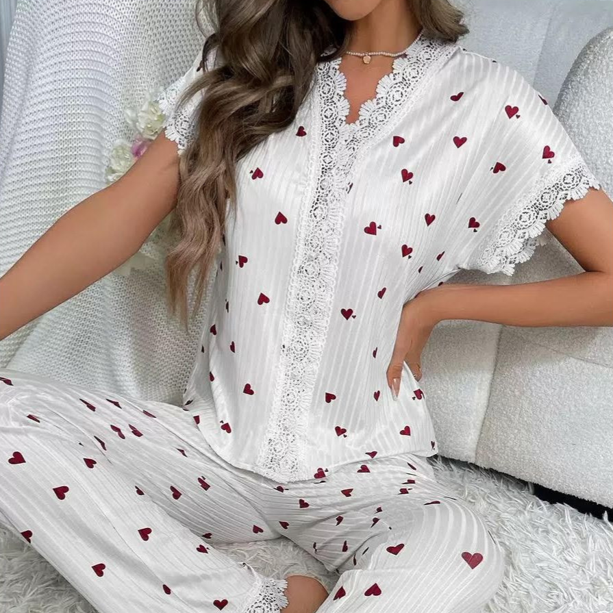 White pajama set with red heart pattern, featuring lace trim on the top and pants.
