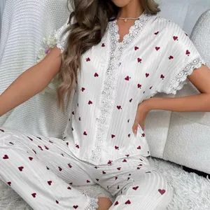 White pajama set with red heart pattern, featuring lace trim on the top and pants.
