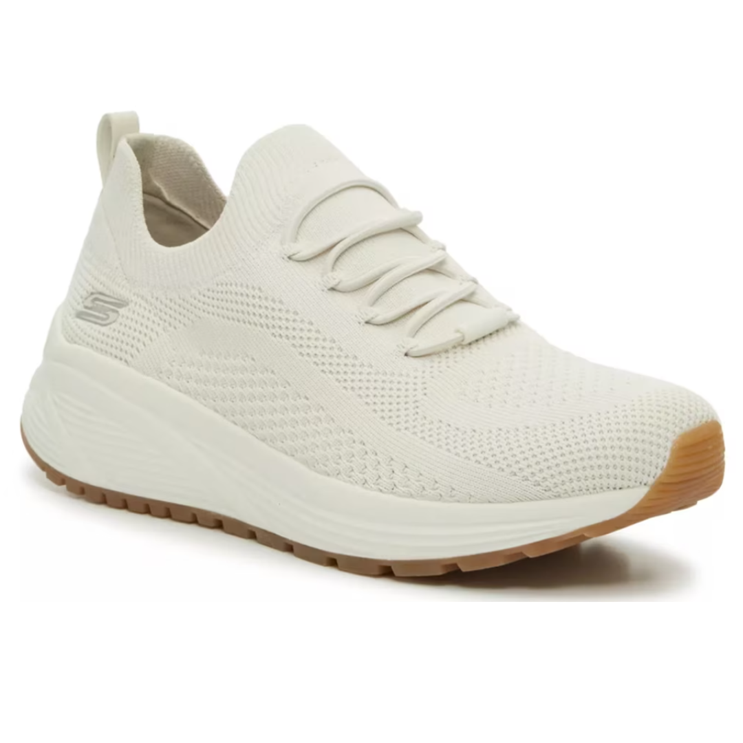 A cream-colored athletic sneaker with a knit upper, lace-up design, cushioned sole, and gum rubber outsole.