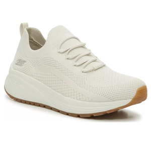 A cream-colored athletic sneaker with a knit upper, lace-up design, cushioned sole, and gum rubber outsole.