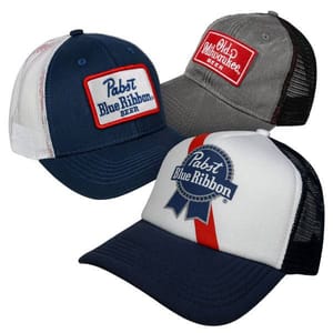 Three trucker hats featuring beer brand logos: two have \“Pabst Blue Ribbon\“ designs in navy and white, and one has \“Old Milwaukee Beer\“ in gray with a red patch.