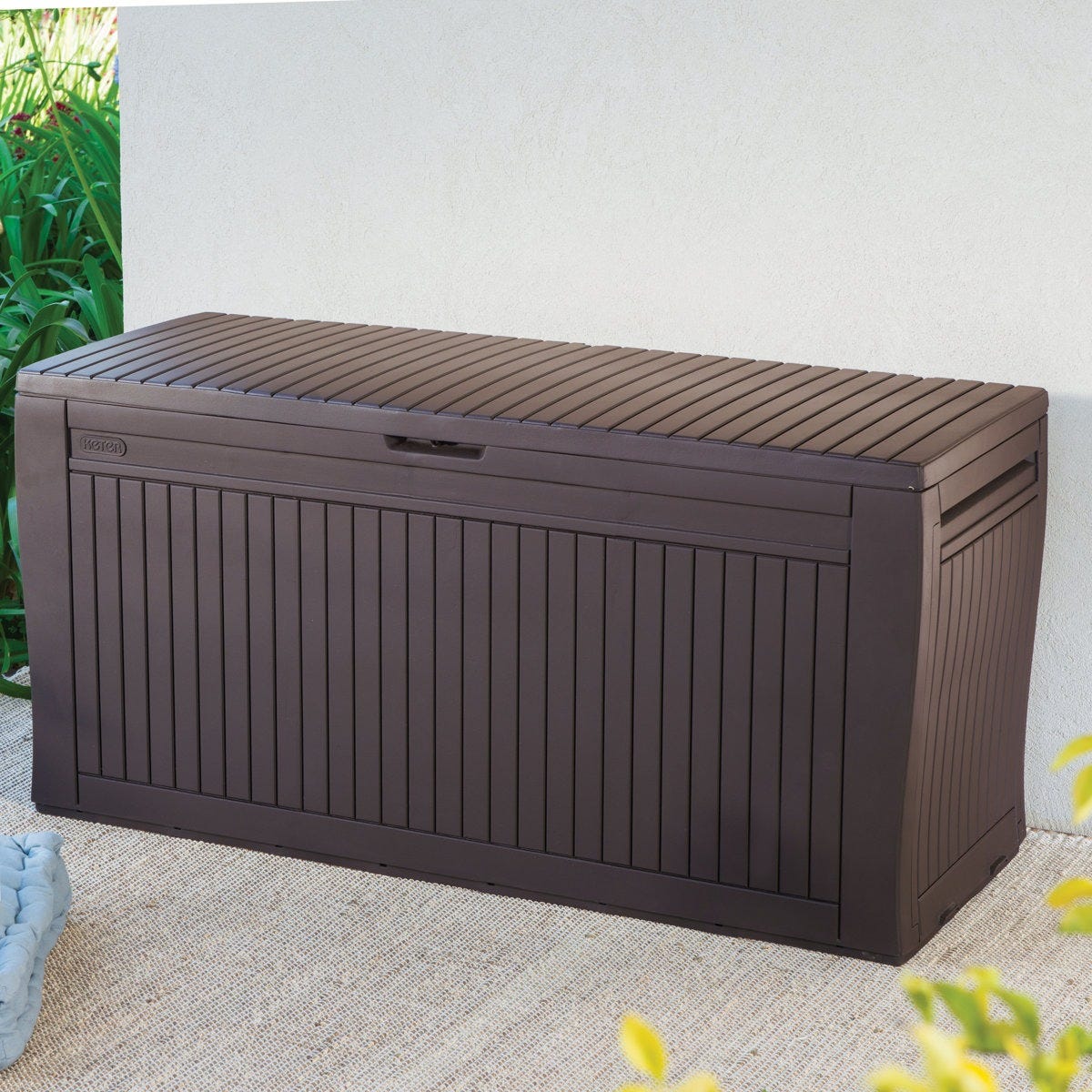 A dark brown outdoor storage bench with a slatted design, suitable for patio use.