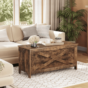 Living room featuring a beige sectional sofa, a rustic wooden chest-style coffee table with an \“X\“ pattern, a white patterned rug, decorative pillows, and a potted plant.