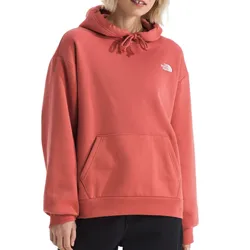 A person wears a coral-colored The North Face hoodie featuring a drawstring hood, a kangaroo pocket, and a small logo on the left chest.