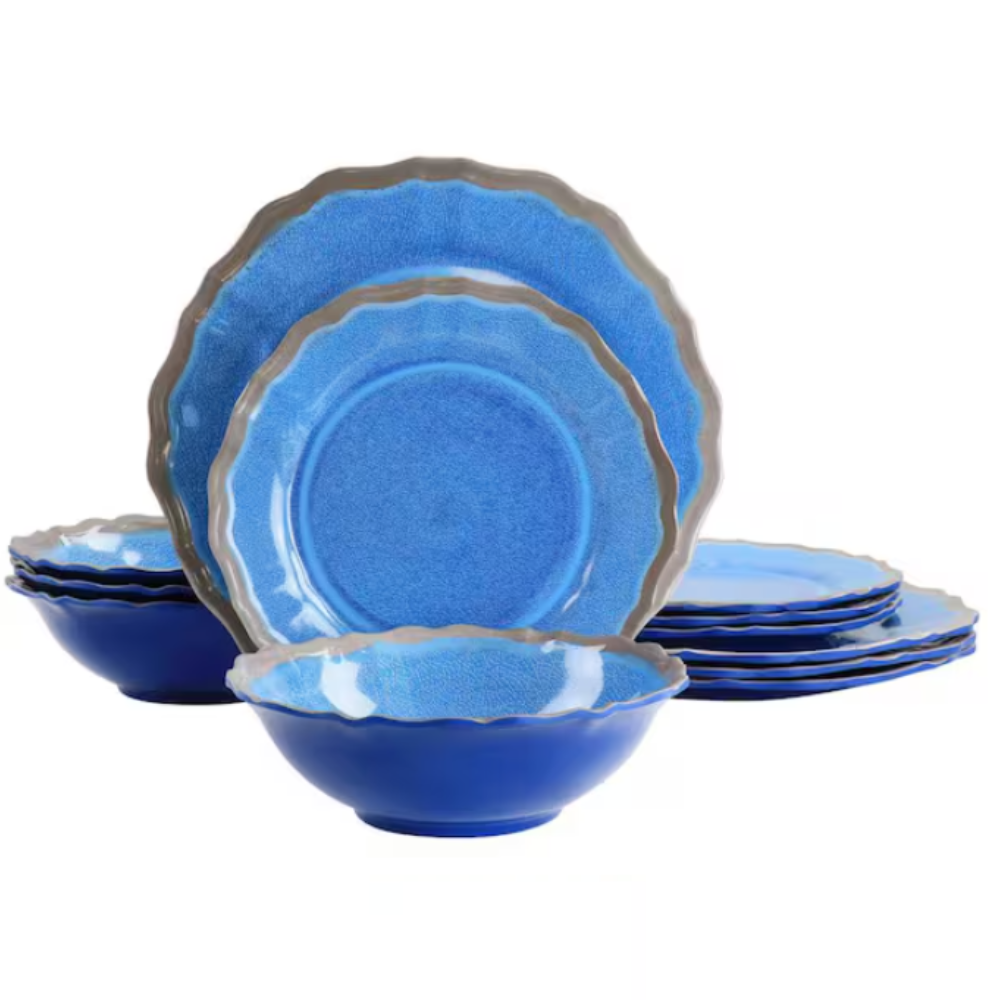 A set of vibrant blue ceramic dinnerware featuring scalloped edges, including plates and bowls.