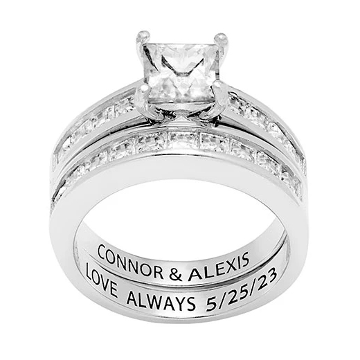 A silver double-band ring set with a square-cut diamond and additional small diamonds. The inner band is engraved with \“CONNOR & ALEXIS LOVE ALWAYS 5/25/23.\“