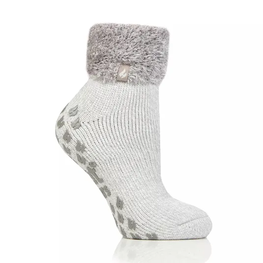 A gray ankle sock with a fluffy cuff and non-slip grip soles, featuring a small tag on the cuff.