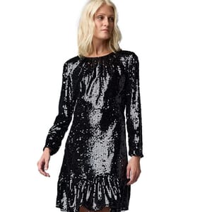 A woman is wearing a black sequin dress with long sleeves and a ruffled hem.