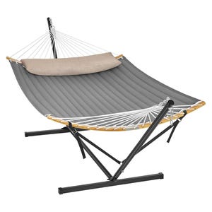 A grey padded hammock with a black metal stand and wooden spreader bars. It includes a beige pillow and features white ropes.