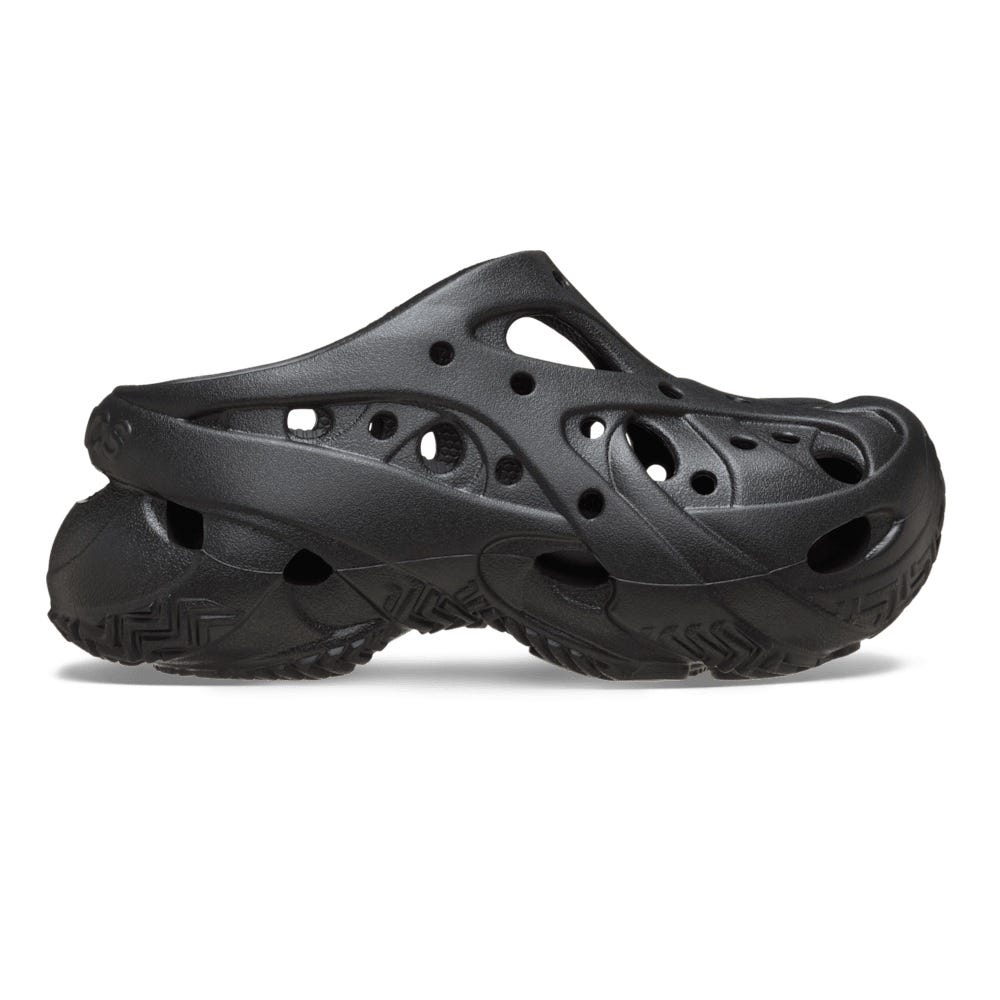 Black slip-on shoe with a sculpted design and multiple cutouts for ventilation and style, featuring a thick sole with a textured tread pattern.