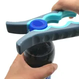 A bottle opener with ergonomic handles is being used to open a bottle cap.