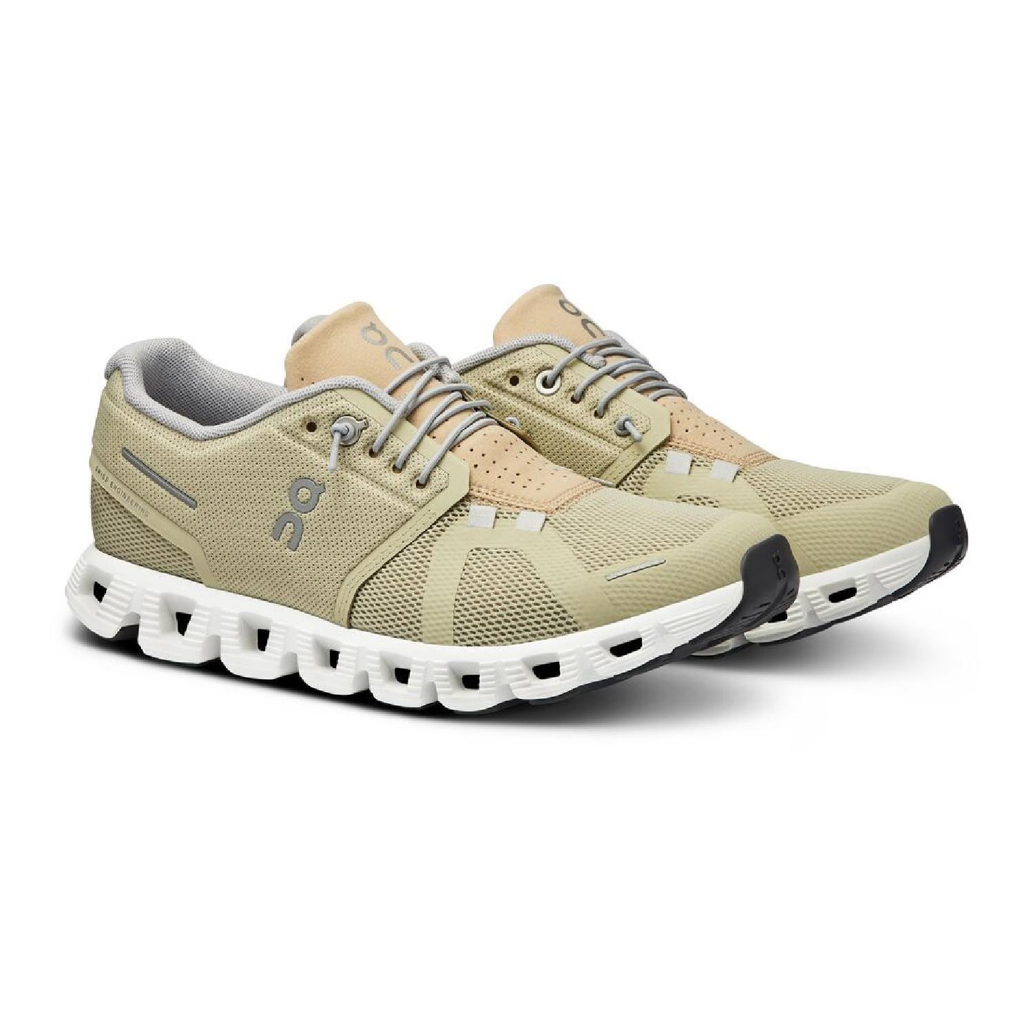 A pair of beige and olive green sneakers with mesh panels and a white serrated sole.