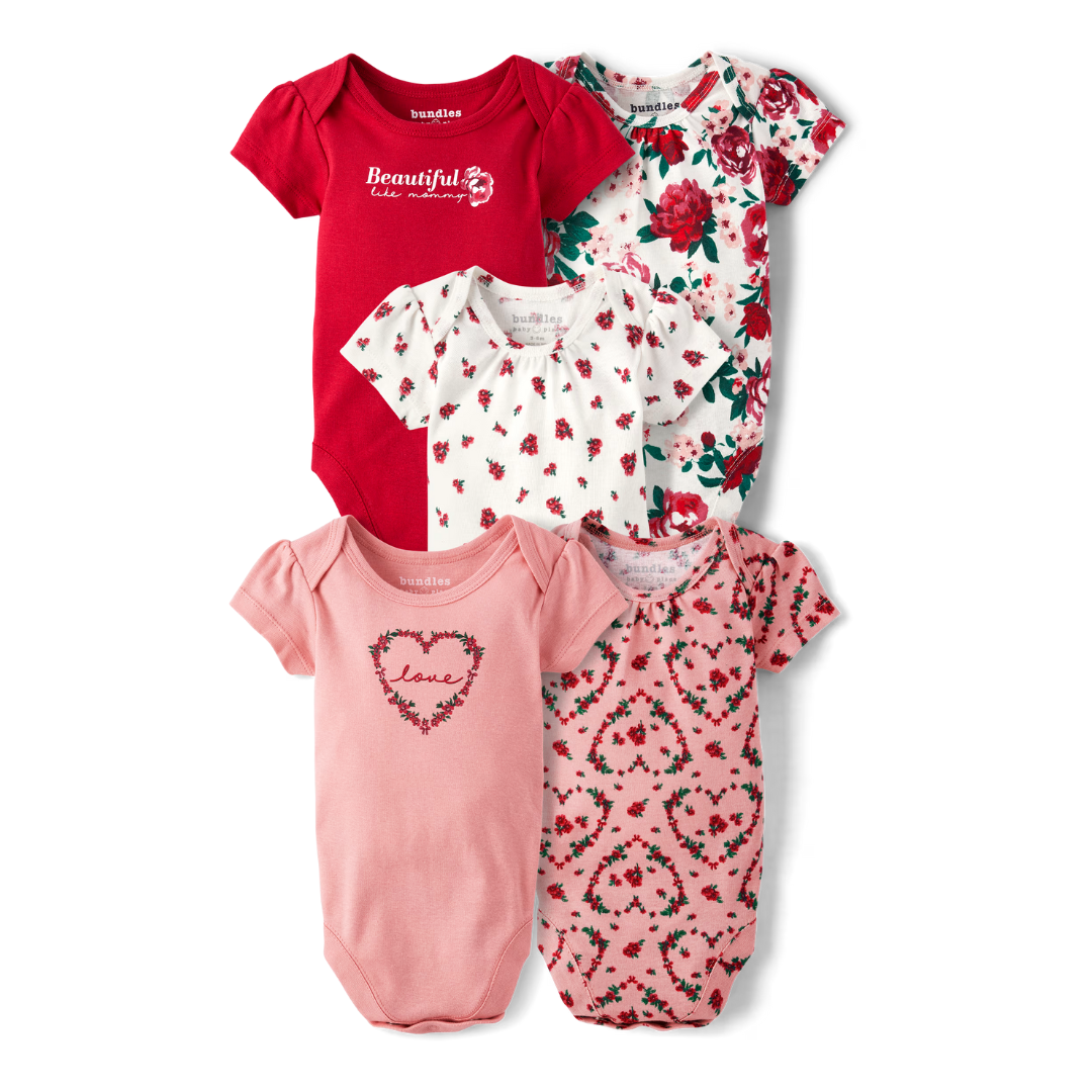 Five baby girl bodysuits in red, light pink, and white, with various floral and heart patterns. Two feature collar details, and all have short sleeves.