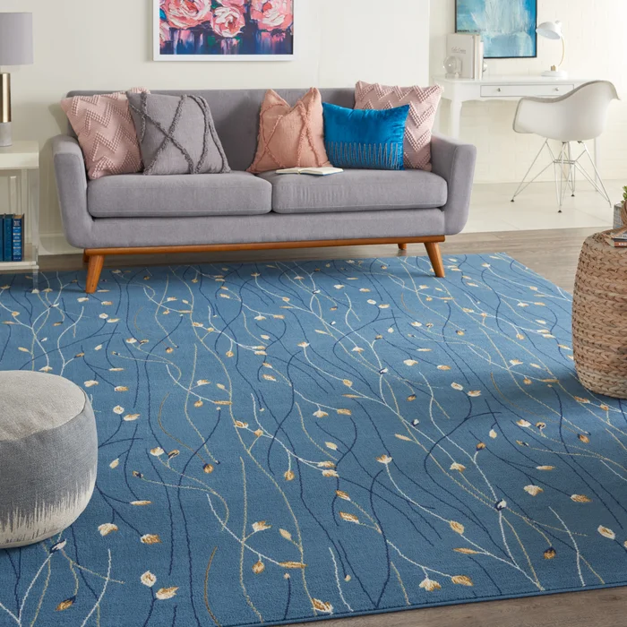 A 5' x 7' blue floral area rug with a delicate pattern of winding stems and small yellow and white flowers, adding a serene touch to the room's decor.