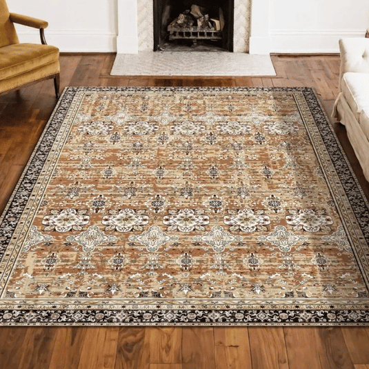 A patterned area rug with intricate floral and geometric designs, featuring a brown, beige, and black color scheme, placed on a wooden floor near a fireplace.