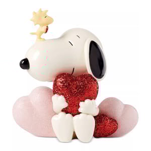 Snoopy holding a red glittery heart while sitting on pink glittery hearts, with Woodstock perched on his nose.