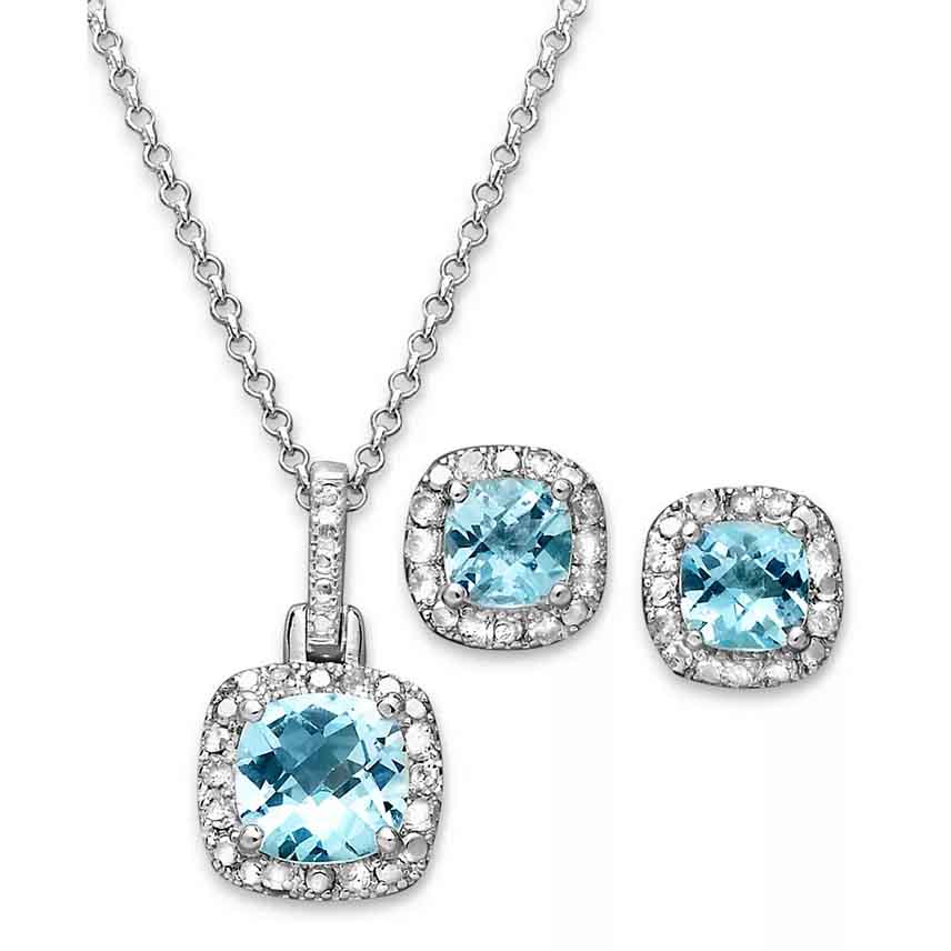 Silver necklace and earring set featuring blue gemstones surrounded by smaller clear stones.