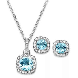 Silver necklace and earring set featuring blue gemstones surrounded by smaller clear stones.
