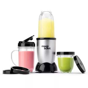 Magic Bullet blender set with three cups of various sizes, one blender base, and lids. Contains smoothies in pink, green, and yellow colors.