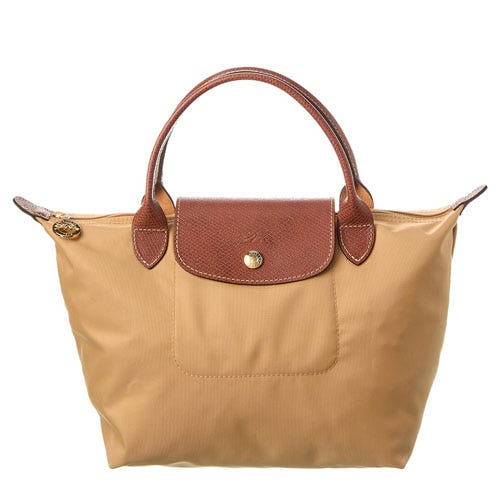 Tan handbag with brown leather handles and a flap closure.