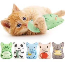 A ginger kitten plays with a green plush toy, part of a set featuring five animal-themed designs, including a crocodile, panda, elephant, apple, and bear. These toys are likely used for cat entertainment.