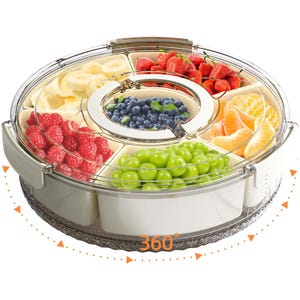 A round, rotating snack tray with a transparent locking lid, featuring six compartments filled with various fruits like strawberries, grapes, blueberries, bananas, raspberries, and orange segments, allowing 360-degree access.