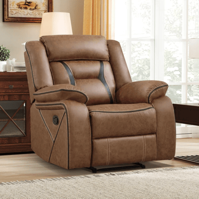 A brown reclining armchair with black accents and visible stitching is positioned near a side table with a lamp in a cozy living room setting.