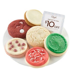 A plate of six assorted cookies featuring red velvet, classic sugar, chocolate chip with icing, and festive green and pink frosted cookies, alongside a $10 off coupon for Cheryl's.