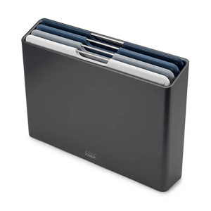 A set of four staggered, color-coded chopping boards in a sleek, upright storage case. The boards are in shades of white and blue, designed for easy storage and organization.