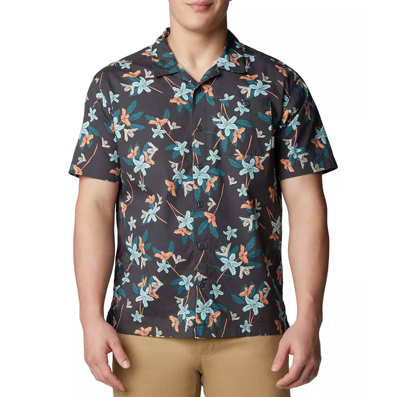 A man wearing a short-sleeved, collared shirt with a floral pattern.