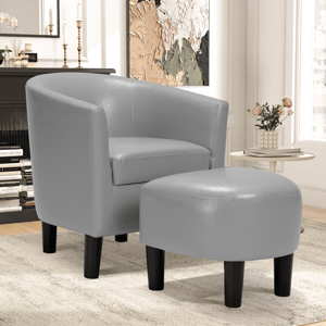 A sleek grey armchair with a matching ottoman featuring black legs, set in a modern living room with a side table, decorative vase, and abstract wall art.