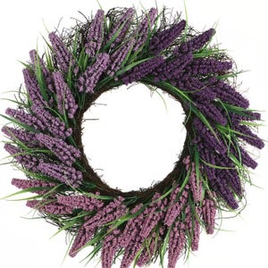 A floral wreath featuring bundles of purple and lavender artificial flowers with green leaves, arranged on a circular brown grapevine base.