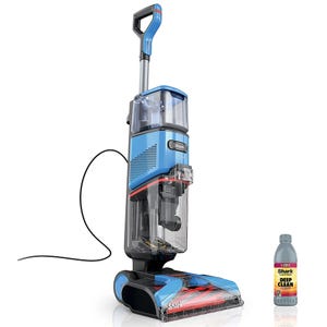 A Shark upright vacuum cleaner designed for deep carpet cleaning is shown, accompanied by a bottle of cleaning solution.