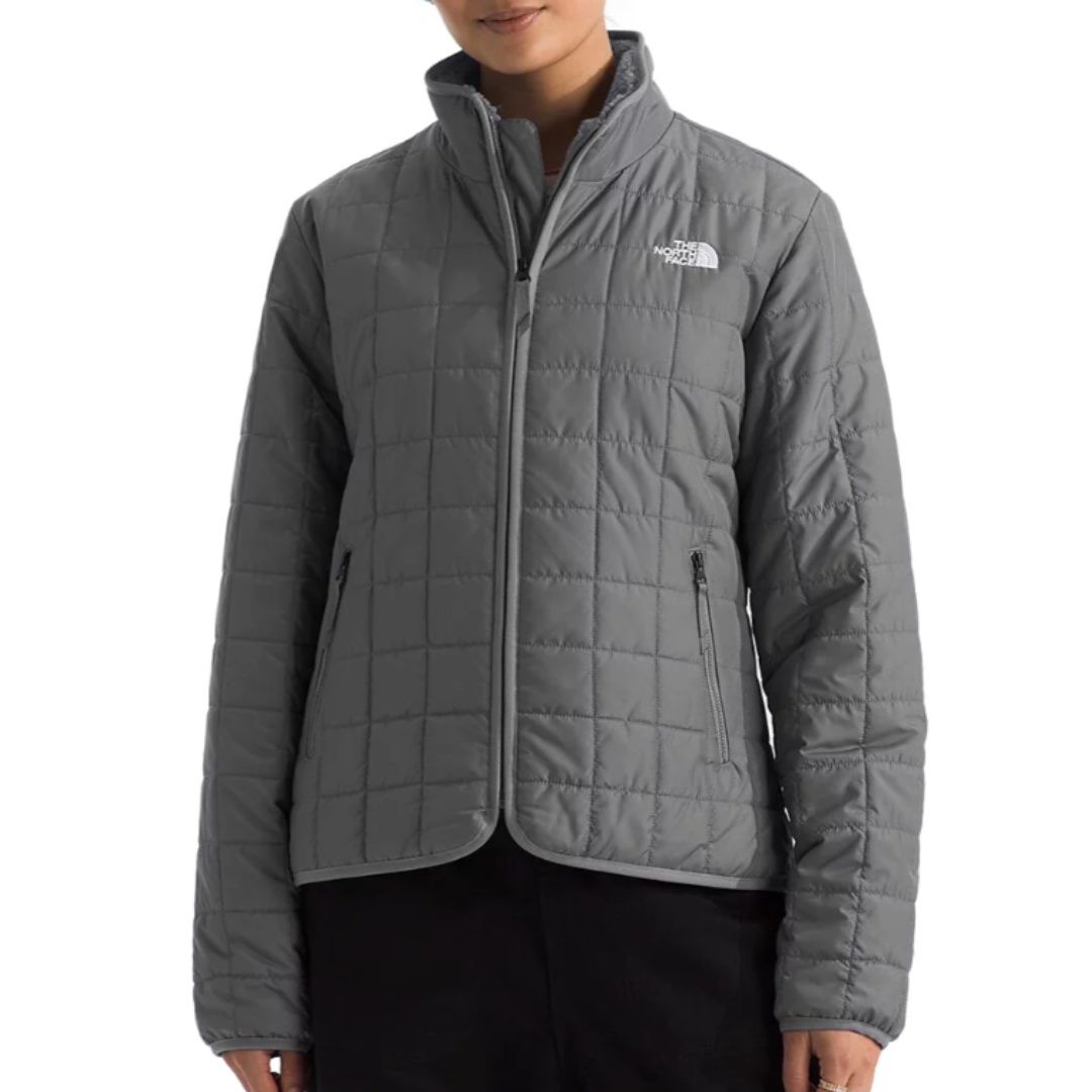 The North Face Junction Jacket is a sleek, quilted jacket in gray featuring a zip-up front, stand collar, and two zippered pockets. The logo is visible on the chest.