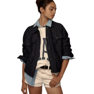 A dark blue bomber jacket with button front and ribbed detailing, worn over a white T-shirt with a letter 'A' and paired with light beige shorts and a striped blue collar shirt.