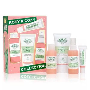 The Mario Badescu Rosy & Cozy Collection includes Rose Body Soap, Rose Hand Cream with Vitamin E, Aloe Facial Spray, and Rose Lip Balm, showcased in a pink box with a holiday theme.
