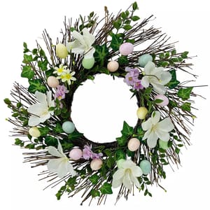 Spring wreath made of twigs, adorned with white flowers, green leaves, and pastel-colored decorative eggs.