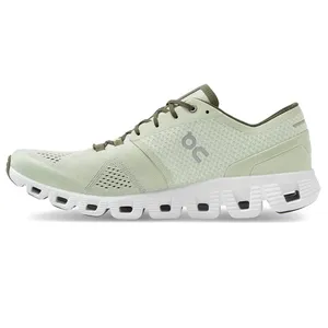 Light green athletic shoe featuring a perforated upper and a white, cushioned sole with distinctive cut-out patterns. The shoe has a logo on the side and lace-up design for closure.