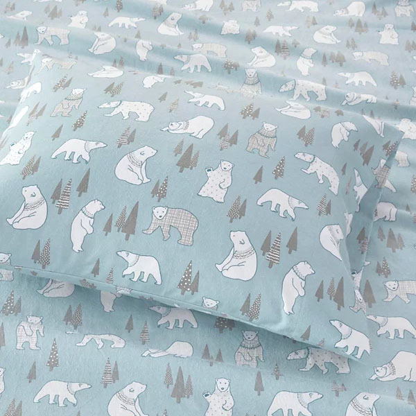 Bedding set with polar bear and pine tree print on a light blue background.