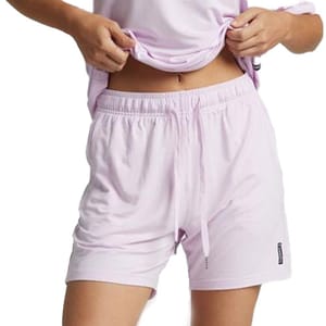 A person wearing light pink drawstring shorts, paired with a matching light pink top.