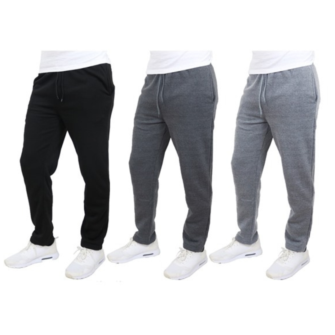 Three pairs of men's jogger pants in black, dark gray, and light gray, each styled with a drawstring waist and paired with white sneakers.