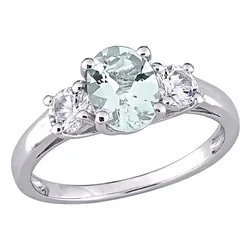 A silver ring featuring an oval-shaped pale green gemstone flanked by two round clear stones in a three-stone setting.