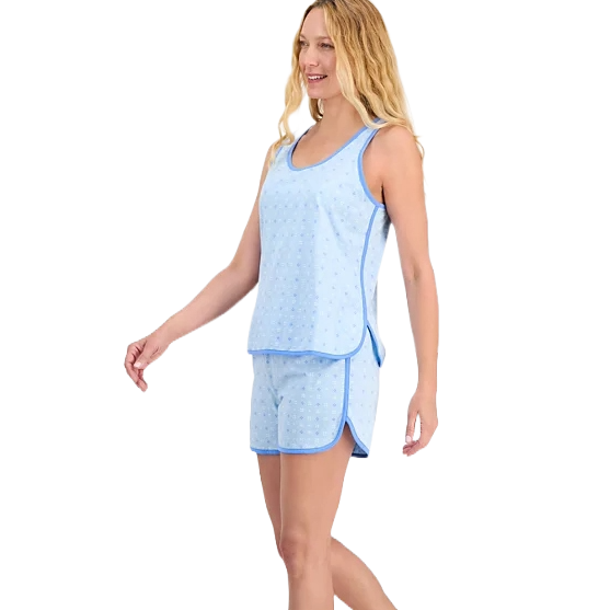 A woman is modeling a light blue, sleeveless 2-piece pajama set with a tank top and shorts, featuring a subtle pattern and contrasting blue trim.