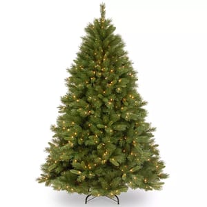 A pre-lit artificial Christmas tree with green branches and warm white lights, standing on a metal base.
