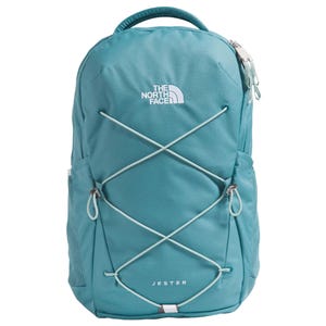 The North Face Jester backpack in teal features a flexible bungee cord system on the front, side mesh pockets, and a top handle.