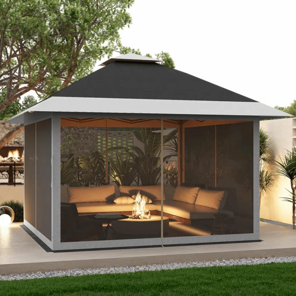 A gazebo with a gray and black roof encloses a cozy seating area with plush cushions around a small fire pit.