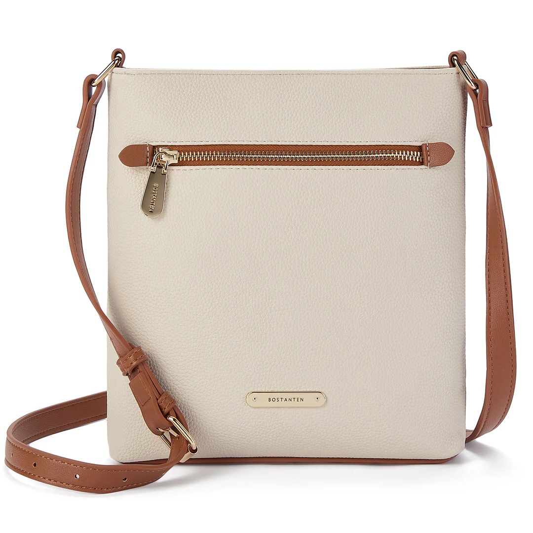 Ivory faux-leather crossbody bag with a front zipper detail and tan strap and accents.